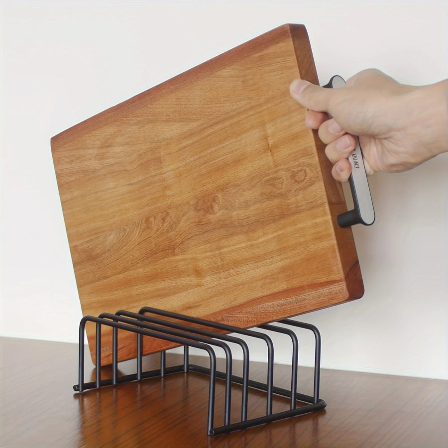 Cutting board holder with a wooden cutting board standing upright in a black steel rack